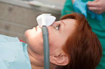 A woman being sedated by dental staff