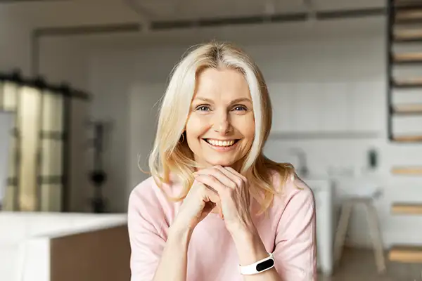 Joyful white woman showing off her beautiful teeth with dental implants from Surf City Oral and Maxillofacial Surgery in Huntington Beach, CA