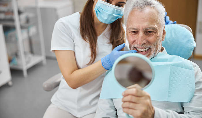 A dentist and patient examining his new all on 4 smile