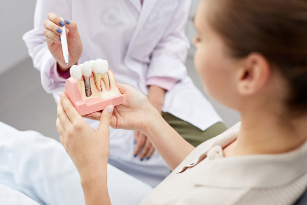 Dentist instructs patient with dental implant 3D modelHuntington Beach, CA