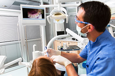 Dentist viewing a patient's teeth in intraoral camera.