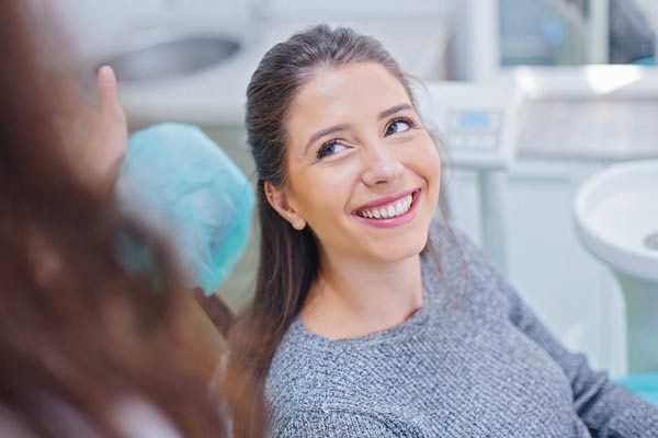 Woman smiling while at dental office at Surf City Oral and Maxillofacial Surgery in Huntington Beach, CA